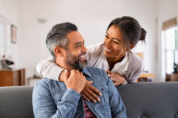 A couple sharing a smile on the couch together