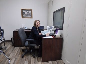 Julie performing a hearing test at the hearing booth